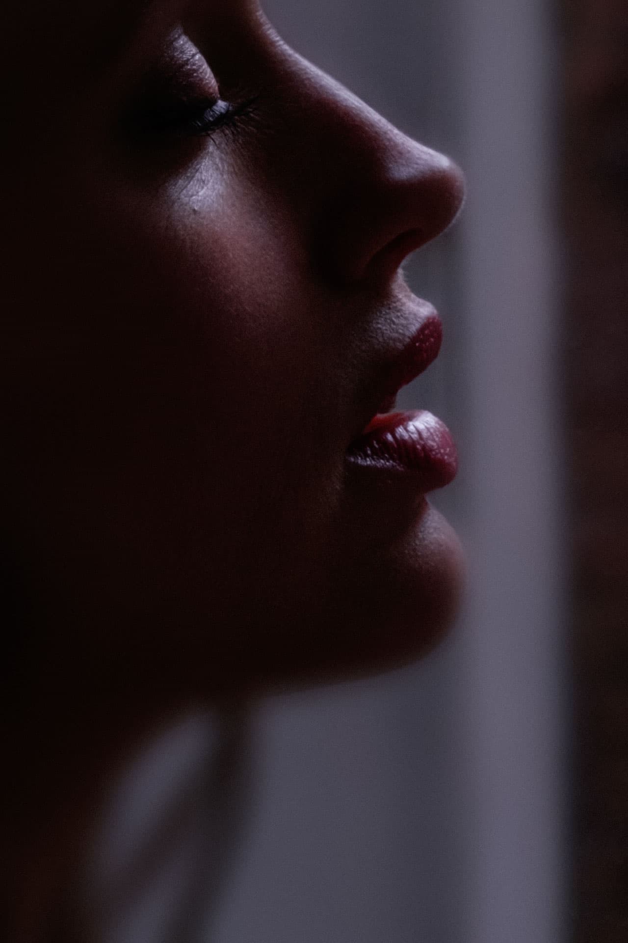 Profil d'une belle jeune femme, les yeux fermés, la bouche entre-ouverte.